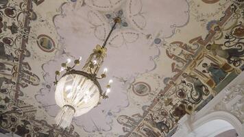 Large ceiling with glass chandelier. Action. A painted ceiling with a sparkling chandelier. video