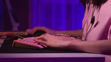 Close-up of young woman playing computer game. Stock footage. Gamer plays on computer by pressing keyboard and mouse. Girl plays computer games with keyboard video