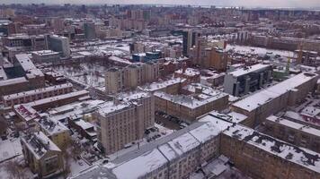 A bird's-eye view of the winter city. Clip. Winter view with built-up houses and churches standing around beautiful snowy landscapes. video