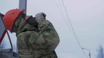 Builder with walkie-talkie on street at construction site. Clip. Builder in uniform is talking on walkie-talkie on street. Builder warns on radio about situation at construction site video