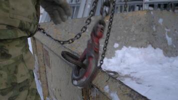 Close-up of builder hooking hook to load. Clip. Fixing hook to lift load. Hook trailer to heavy load for lifting by crane video