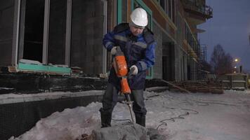 Cement split. Clip. A man in a uniform working with special equipment in winter. video