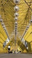 People walking inside pedestrian bridge in Moscow, Russia. Action. View inside of Andreyevskiy bridge with bright yellow metal beams and hanging lanterns. video