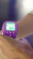 Concept of coronavirus, detection of elevated temperature. Media. Close up of male hand measuring temperature of several people with non contact infrared thermometer. video