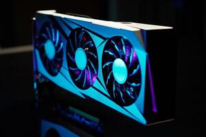 Close-up of high-performance graphics card with three cooling fans with neon lighting. Modern card for gaming and advanced computing photo
