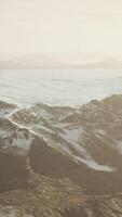 large snow patch left over on the volcanic rock field of a mountain in summer video