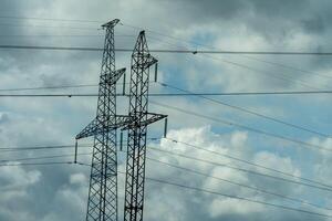 High voltage towers with sky background. Power line support with wires for electricity transmission. High voltage grid tower with wire cable at distribution station. Energy industry, energy saving photo