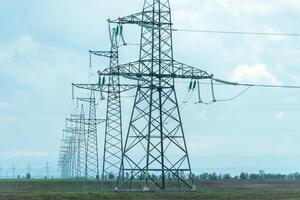 High voltage towers with sky background. Power line support with wires for electricity transmission. High voltage grid tower with wire cable at distribution station. Energy industry, energy saving photo