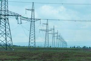 High voltage towers with sky background. Power line support with wires for electricity transmission. High voltage grid tower with wire cable at distribution station. Energy industry, energy saving photo