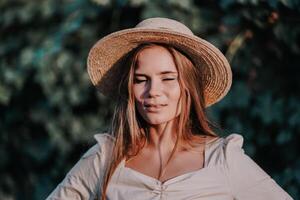 Woman with straw hat stands in front of vineyard. She is wearing a light dress and posing for a photo. Travel concept to different countries photo
