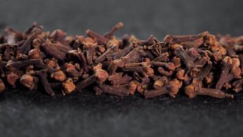 Spices dried cloves on a black background close-up for cooking. The kidneys contain the amount of essential oil which includes eugenol, acetylievgenol, as well as tannins, organic acids oleanolic acid video