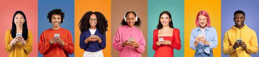 A group of seven young people stands in a row, each engaged with their smartphones. They are surrounded by vibrant, solid-colored backgrounds that enhance their cheerful expressions and style. photo
