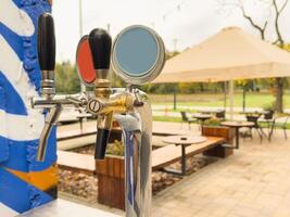 Bar counter with draft beer taps in open-air cafe photo