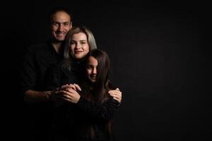 Happy young family with one child having fun together isolated on black. photo
