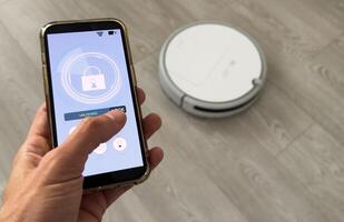 smart house, home automation, device with app icons. Man uses his smartphone with smarthome security app to unlock the door of his house. photo
