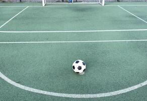 The ball in grass. The sideline. Fresh green grass. Black and white ball. photo