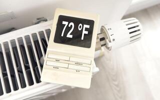 Adjusting the radiator temperature using a thermostat in an apartment with central heating photo