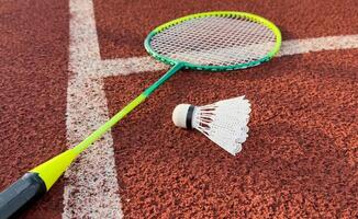 Cream white badminton shuttlecock and racket on badminton court, copy space, soft and selective focus. photo