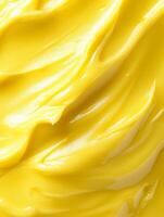 Close-up of smooth yellow cream with a glossy finish, showcasing a rich and creamy texture perfect for skincare or moisturizing products. photo