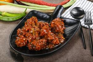Manchurian chicken with sauce and spices photo