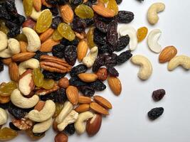 Mixed Nuts Almonds, Walnuts, Cashews, Hazelnuts, Dried Prunes and Raisins. Different Nut Mix. Various Nuts and Dried Fruits on white background. photo