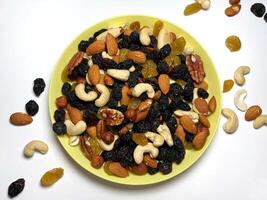 Mixed Nuts on a plate bowl Almonds, Walnuts, Cashews, Hazelnuts, Dried Prunes and Raisins. Different Nut Mix. photo