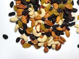 Mixed Nuts Almonds, Walnuts, Cashews, Hazelnuts, Dried Prunes and Raisins. Different Nut Mix. Various Nuts and Dried Fruits on white background. photo