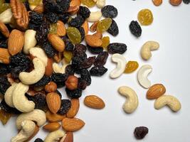 Mixed Nuts Almonds, Walnuts, Cashews, Hazelnuts, Dried Prunes and Raisins. Different Nut Mix. Various Nuts and Dried Fruits on white background. photo