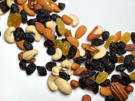 Mixed Nuts Almonds, Walnuts, Cashews, Hazelnuts, Dried Prunes and Raisins. Different Nut Mix. Various Nuts and Dried Fruits on white background. photo