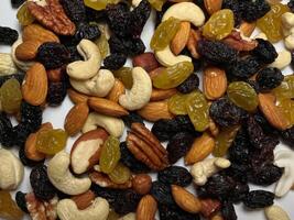 Mixed Nuts Almonds, Walnuts, Cashews, Hazelnuts, Dried Prunes and Raisins. Different Nut Mix. Various Nuts and Dried Fruits on white background. photo