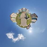 modern low-rise residential townhouse on surface of little tiny planet in blue sky with sun. Transformation of spherical panorama 360 degrees. Spherical abstract aerial view. Curvature of space. photo