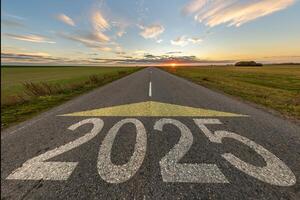 numbers 2025 and start on asphalt road highway with cracks with sunrise or sunset sky background. concept of destination in future, freedom, work start, run, planning, challenge, target, new year photo