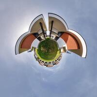 modern low-rise residential townhouse on surface of little tiny planet in blue sky with sun. Transformation of spherical panorama 360 degrees. Spherical abstract aerial view. Curvature of space. photo