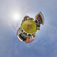 modern low-rise residential townhouse on surface of little tiny planet in blue sky with sun. Transformation of spherical panorama 360 degrees. Spherical abstract aerial view. Curvature of space. photo