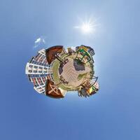 modern low-rise residential townhouse on surface of little tiny planet in blue sky with sun. Transformation of spherical panorama 360 degrees. Spherical abstract aerial view. Curvature of space. photo