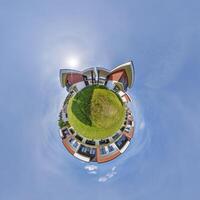 modern low-rise residential townhouse on surface of little tiny planet in blue sky with sun. Transformation of spherical panorama 360 degrees. Spherical abstract aerial view. Curvature of space. photo