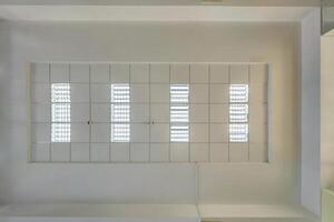cassette stretched or suspended ceiling with square halogen spots lamps and drywall construction in empty room in house or office. Looking up view photo