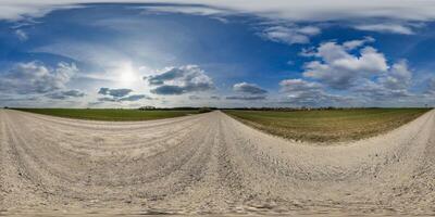 spherical 360 hdri panorama on roadside of gravel road with clear clouds in thunderstorm front dark sky in equirectangular seamless projection, as skydome replacement in drone panoramas photo