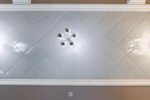 suspended ceiling with halogen spots lamps and drywall construction in empty room in apartment or house. Stretch ceiling white and complex shape. photo
