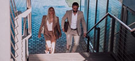 Modern business couple after a long day's work, walking together towards the comfort of their home, embodying the perfect blend of professional success and personal contentment. photo