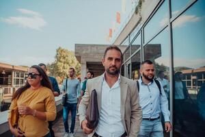 A diverse group of businessmen and colleagues walking together by their workplace, showcasing collaboration and teamwork in the company. photo