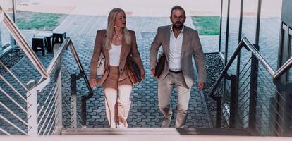Modern business couple after a long day's work, walking together towards the comfort of their home, embodying the perfect blend of professional success and personal contentment. photo