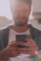 A young man utilizes his smartphone outdoors, showcasing the seamless integration of technology and mobility in modern professional life. photo