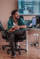 A programmer diligently testing smartphone applications while sitting in their office. photo