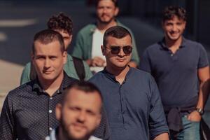 A diverse group of businessmen and colleagues walking together by their workplace, showcasing collaboration and teamwork in the company. photo