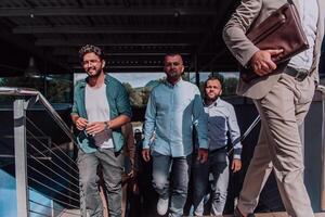 A diverse group of businessmen and colleagues walking together by their workplace, showcasing collaboration and teamwork in the company. photo