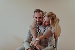 A business couple posing for a photograph together against a beige backdrop, capturing their professional partnership and creating a timeless image of unity and success. photo