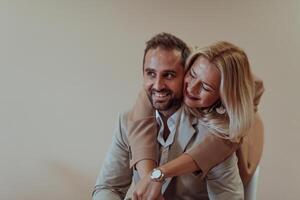 A business couple posing for a photograph together against a beige backdrop, capturing their professional partnership and creating a timeless image of unity and success. photo