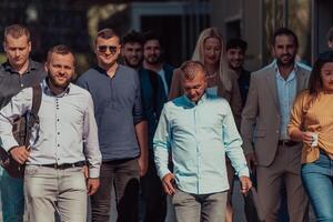 A diverse group of businessmen and colleagues walking together by their workplace, showcasing collaboration and teamwork in the company. photo