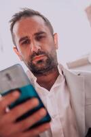 A businessman using his smartphone outdoors, showcasing the seamless integration of technology and mobility in modern professional life. photo